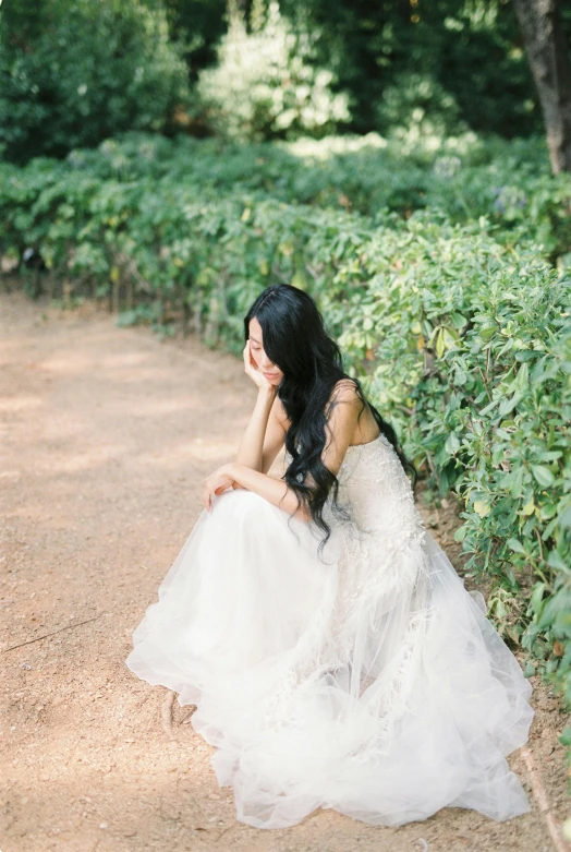 a woman in a wedding dress sitting on a path, by Tan Ting-pho, unsplash, romanticism, long flat hair, slightly pixelated, vera wang couture, botanical garden
