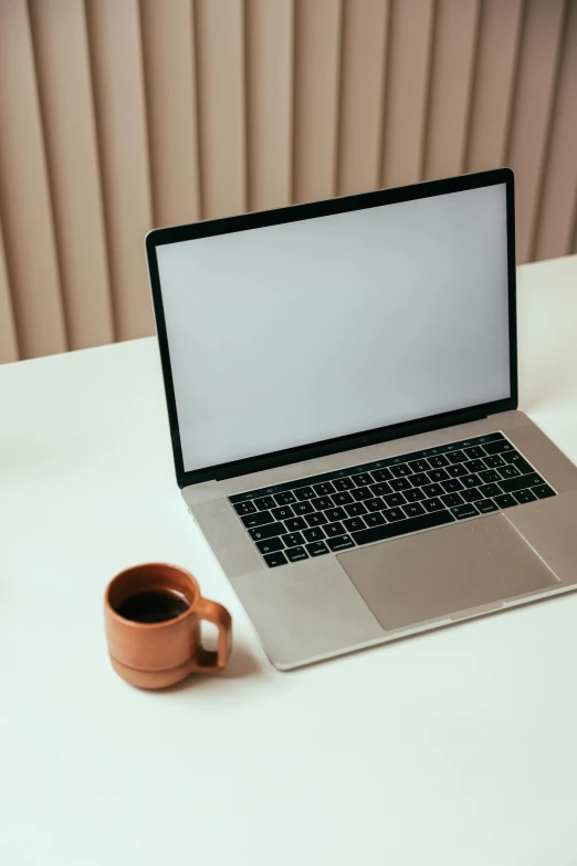 a laptop computer sitting on top of a white table, by Carey Morris, coffee cup, brown, no text, online