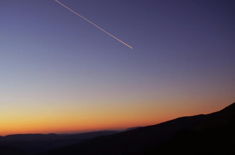 a plane is flying over the mountains at sunset, by Niko Henrichon, unsplash contest winner, postminimalism, meteor, space station, thin straight lines, pastel sunset