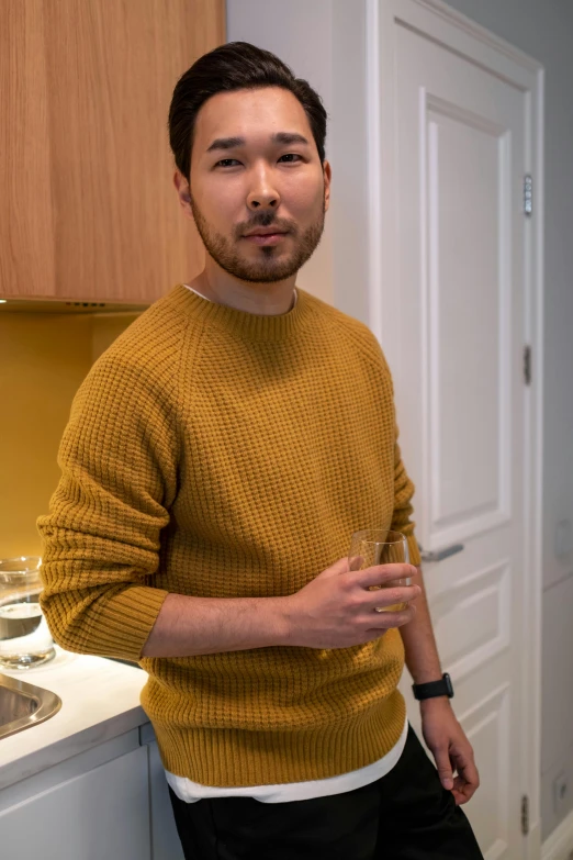 a man standing in a kitchen next to a sink, a picture, by Eero Järnefelt, reddit, shin hanga, wearing casual sweater, an ultra realistic 8k octa photo, yellow hue, handsome chad chin