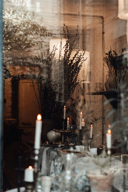 a couple of candles sitting on top of a table, inspired by Elsa Bleda, trending on unsplash, baroque, scene from a dinner party, tall windows lit up, charcoal and silver color scheme, southern gothic scene