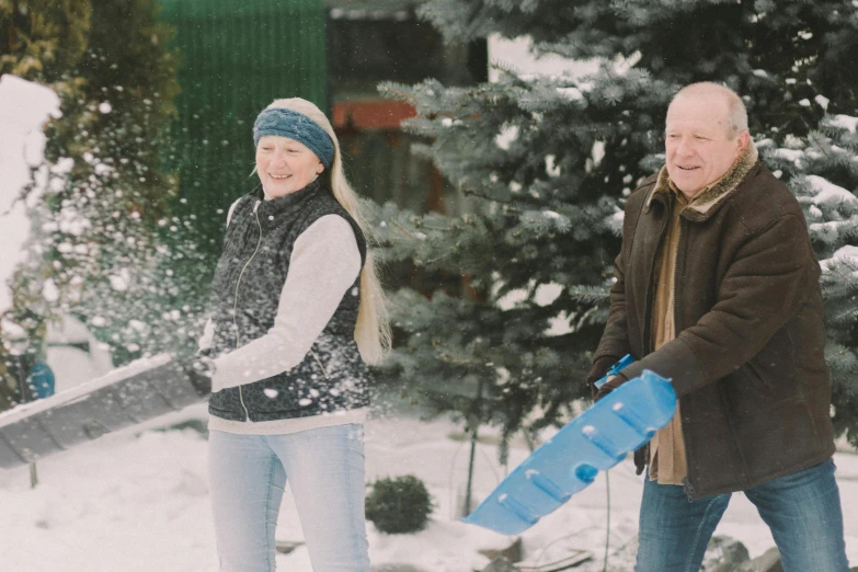 a man and a woman are playing in the snow, pexels contest winner, hurufiyya, gardening, avatar image, high resolution photo, two old people