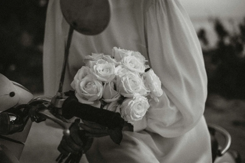 a black and white photo of a woman holding a bouquet of flowers, inspired by Nell Dorr, pexels contest winner, white roses, white hanfu, style of atget, monochrome:-2