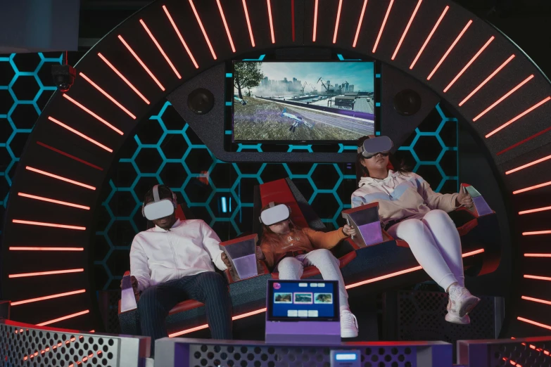 a group of people sitting on top of a stage, a hologram, pexels contest winner, interactive art, vr helmet on man, arcade game, inside an underwater train, mecca