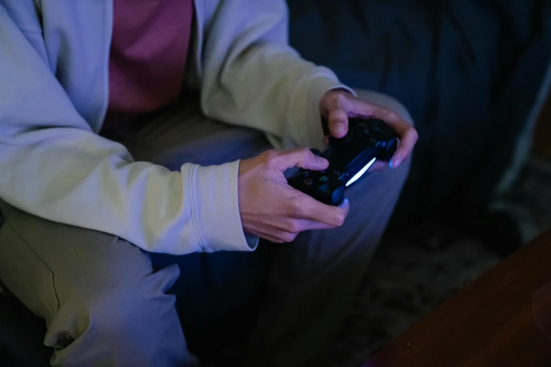 a person sitting on a couch holding a game controller, inspired by Elsa Bleda, pexels, avatar image, evening time, gaming room, instagram post