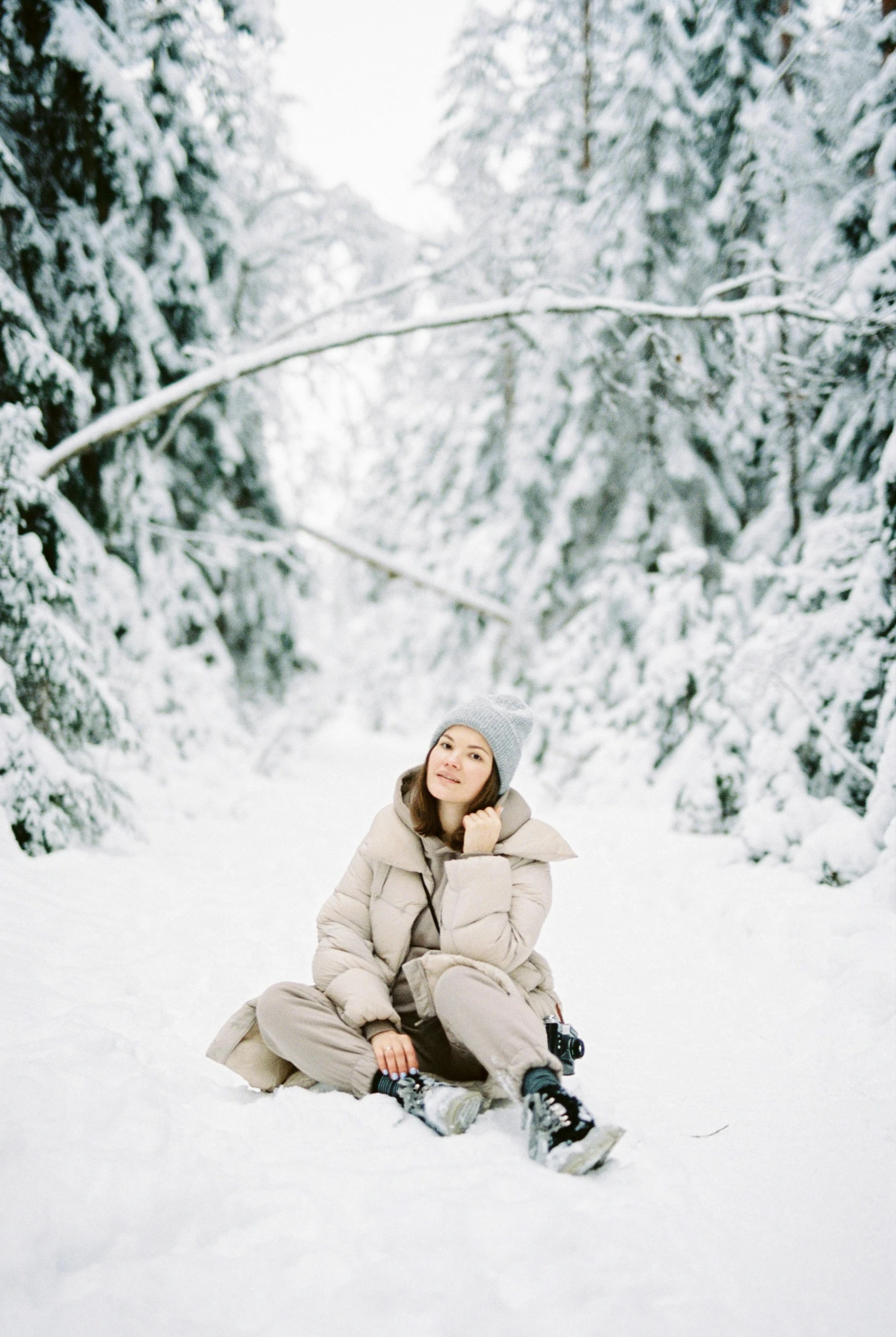 a woman sitting in the snow with a snowboard, by Zofia Stryjenska, pexels contest winner, kodak portra film, lying on the woods path, an all white human, a handsome