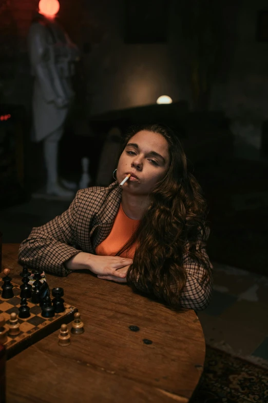 a woman sitting at a table with a chess board, a portrait, inspired by Elsa Bleda, pexels contest winner, florence pugh, smoking a joint, in a basement, ( ( theatrical ) )