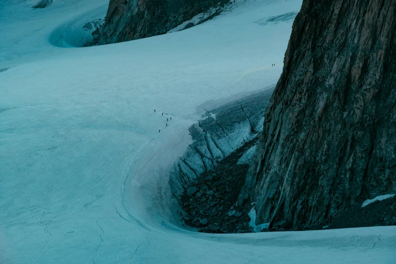 a man riding skis down a snow covered slope, a detailed matte painting, by Andrew Geddes, pexels contest winner, les nabis, blue glacier, people watching around, deep crevices of stone, top - down photograph