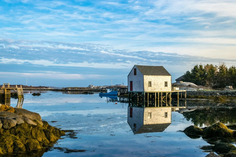 a house sitting on top of a rock next to a body of water, by Jessie Algie, pexels contest winner, harbour, water reflections, new england architecture, panoramic
