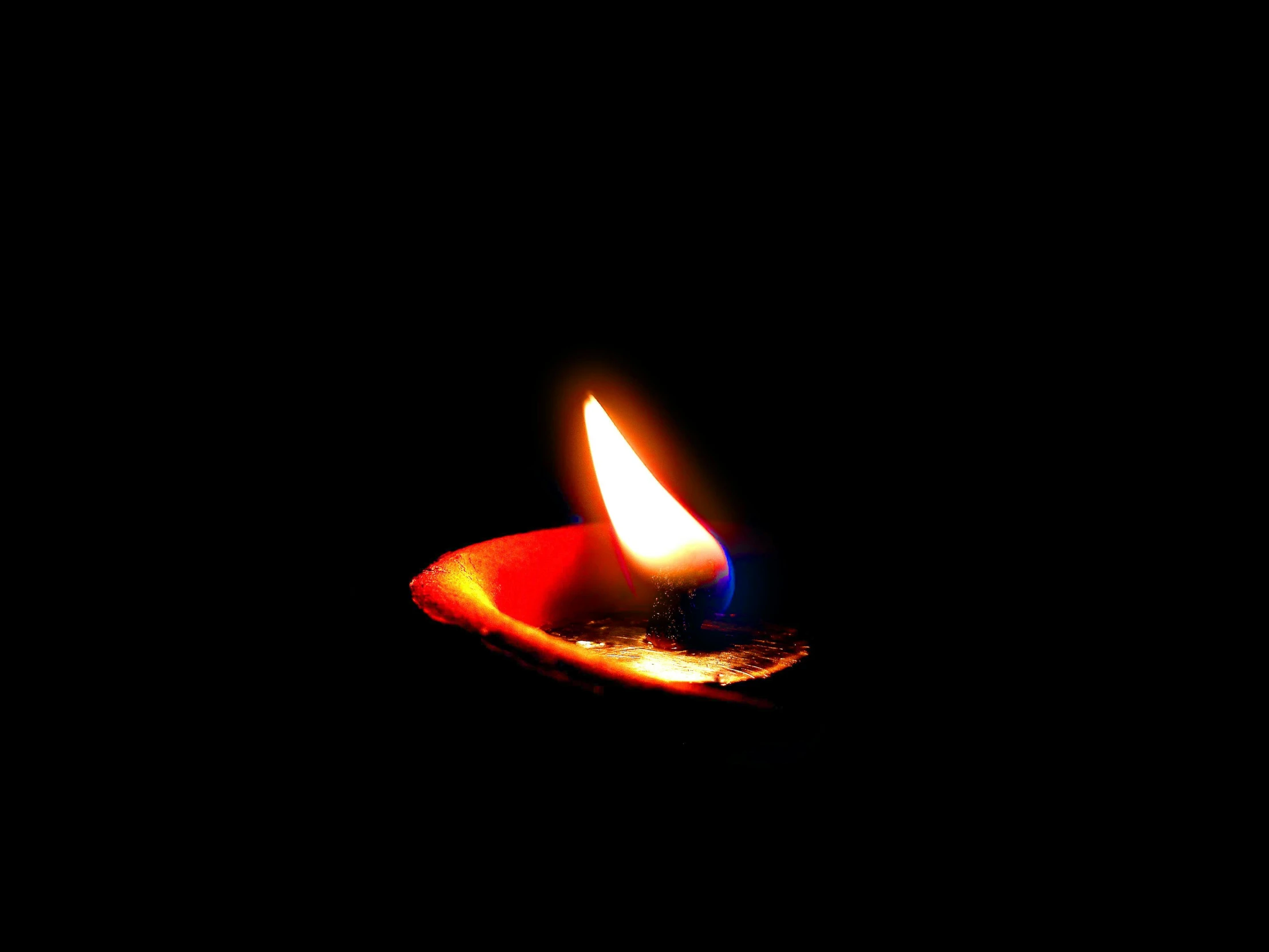 a close up of a lit candle in the dark, a picture, by David Garner, pexels, in black blue gold and red, instagram picture, an orange, peredvishniki