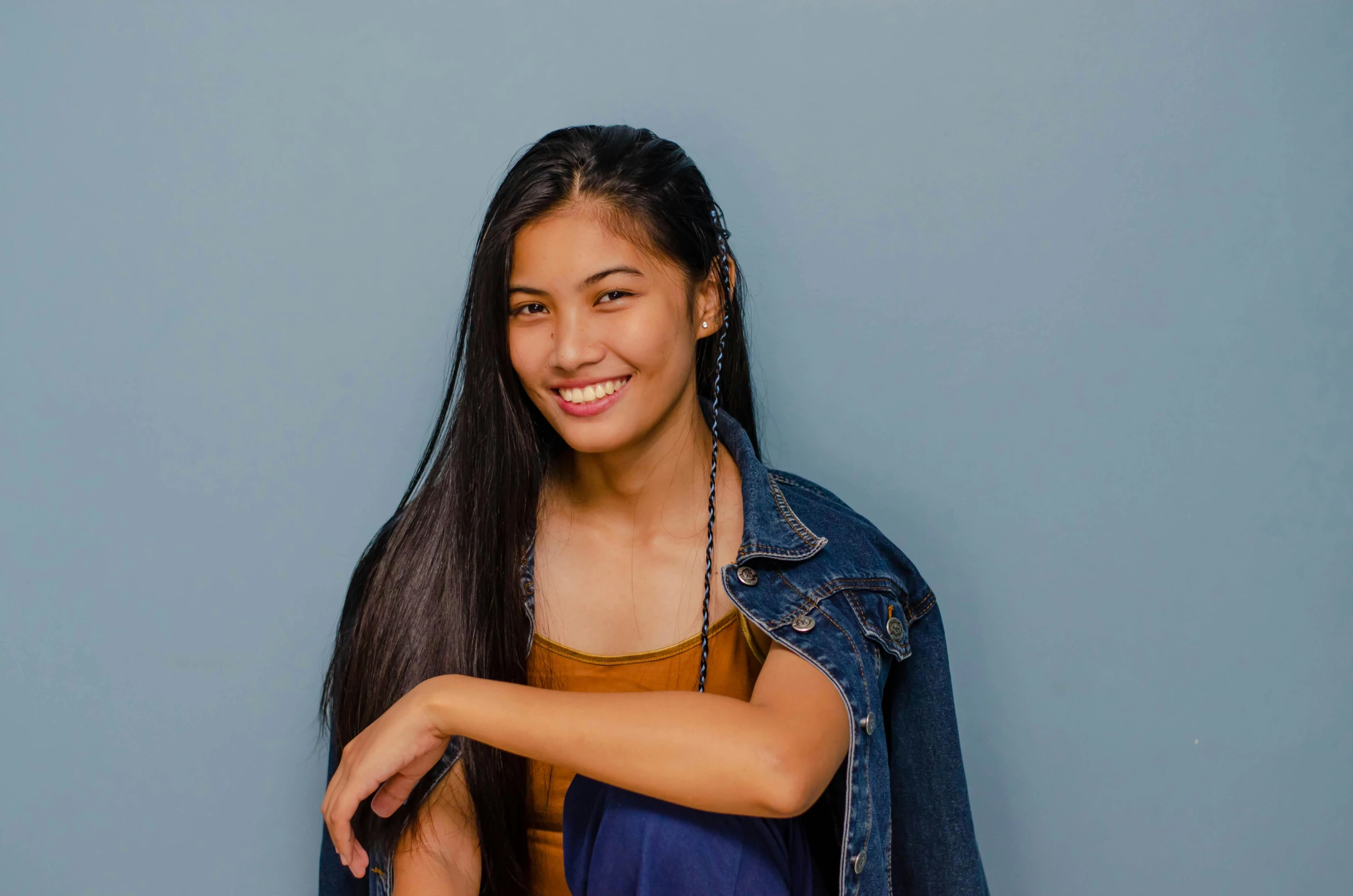 a beautiful young woman posing for a picture, by Olivia Peguero, pexels contest winner, hurufiyya, blue backdrop, mai anh tran, smileing nright, background image