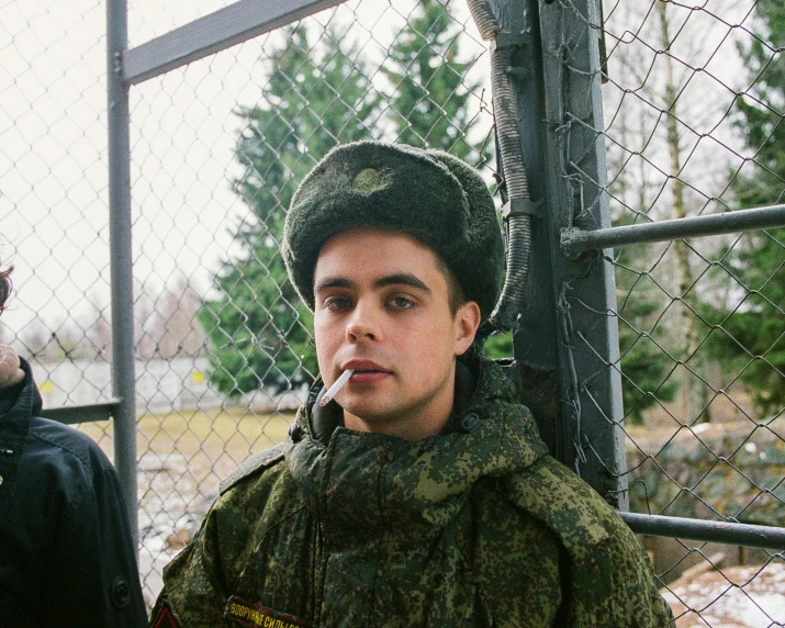 a man in a military uniform smoking a cigarette, by Attila Meszlenyi, flickr, portrait of timothee chalamet, russia in 2 0 2 1, rapper, 2000s photo