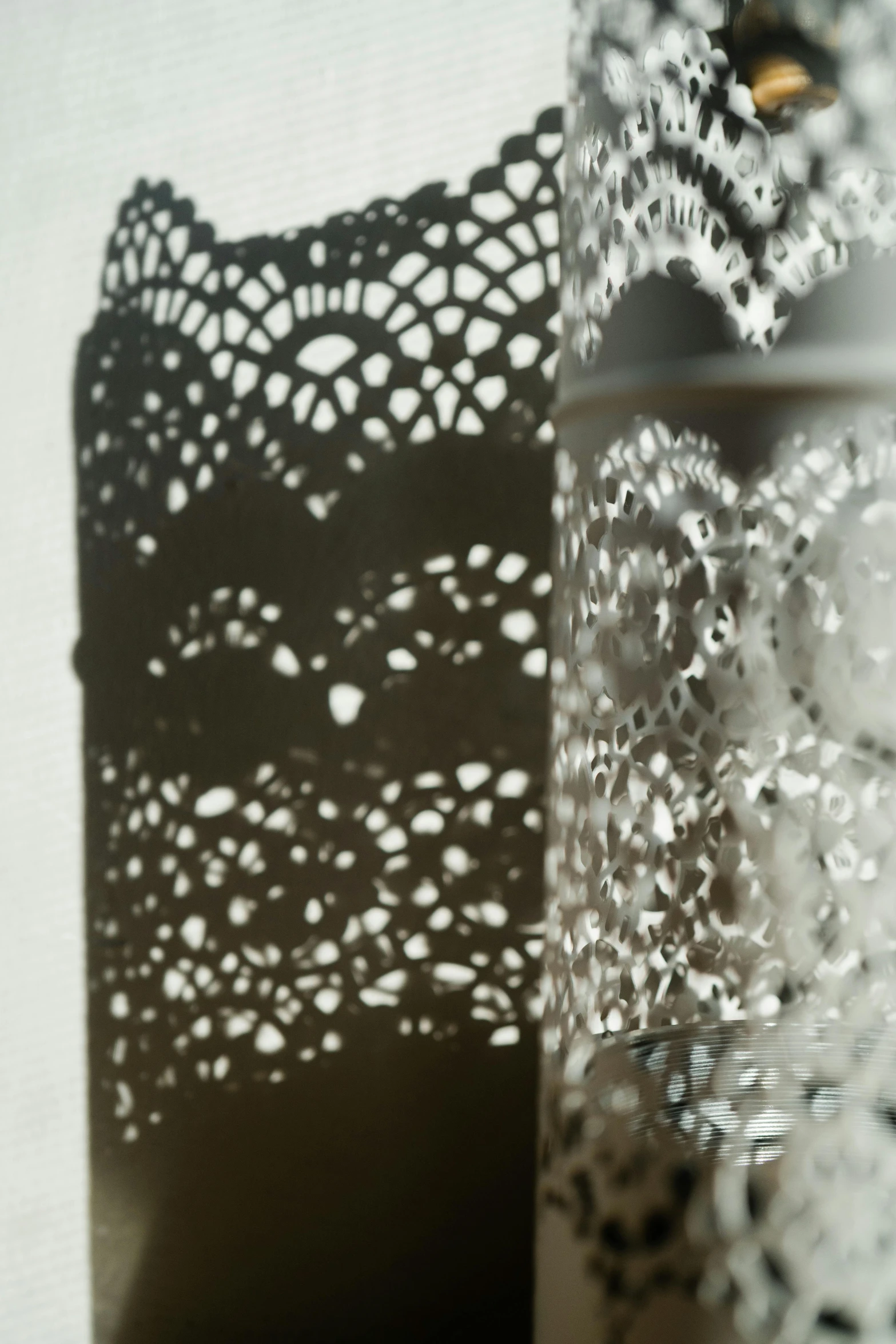 two vases sitting next to each other on a table, inspired by Alberto Morrocco, arabesque, detail shot, metal lace, light and shadow, hoog detail