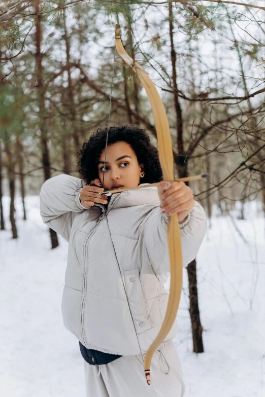 a woman holding a bow and arrow in the snow, pexels contest winner, renaissance, mixed race, wearing a turtleneck and jacket, avatar image, infp young woman