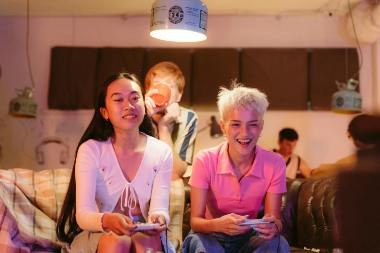 a couple of women sitting on top of a couch, pexels contest winner, gaming room in 2 0 4 0, ruan jia and fenghua zhong, college party, peach and goma style