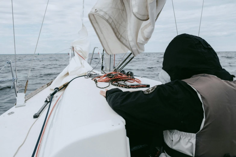 a man that is sitting on a boat in the water, sailing boat, offshore winds, jovana rikalo, helmet view