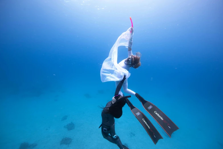 a couple of people that are in the water, unsplash contest winner, happening, aerial silk, side profile in underwater, holding a squid, female ascending into the sky