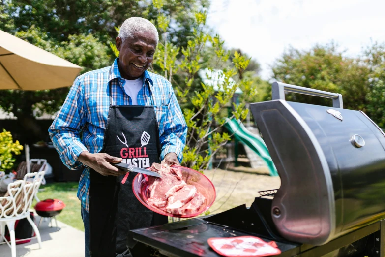 a man standing next to a grill with meat on it, grand master, press, australian, black man