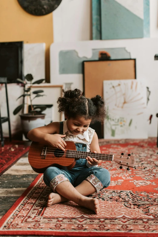 a little girl sitting on the floor playing a guitar, pexels contest winner, an olive skinned, red carpeted floor, thumbnail, in small room