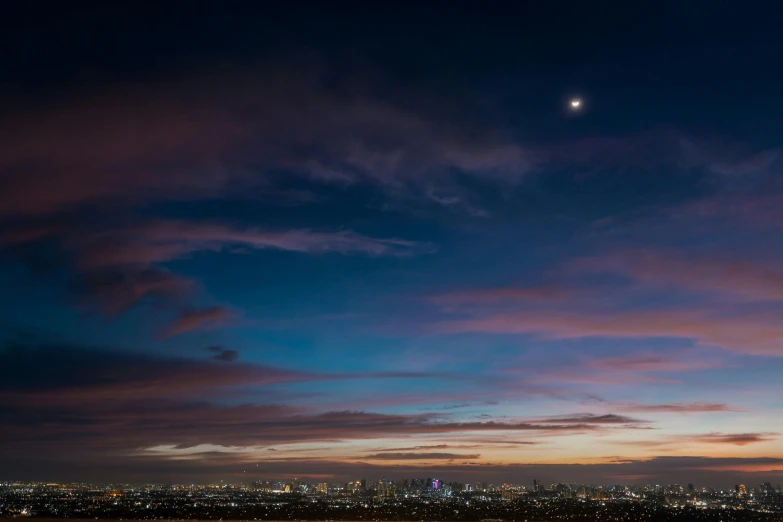 a view of a city at night with the moon in the sky, by Leo Michelson, unsplash contest winner, during an eclipse, los angelos, panorama view of the sky, dusk on jupiter