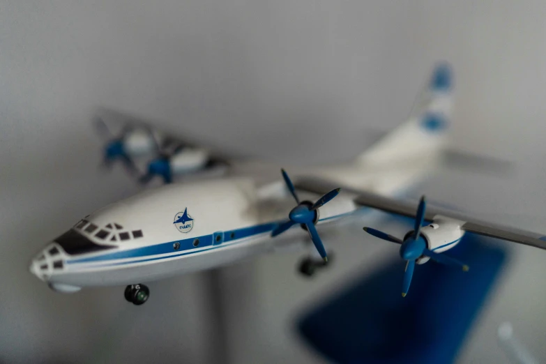 a toy airplane sitting on top of a table, by Adam Marczyński, pexels contest winner, photorealism, white and blue, 1962 soviet, air ships, replica model
