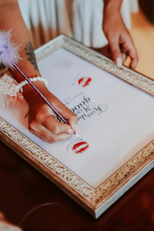 a close up of a person writing on a picture frame, large lips, luxurious wedding, elaborate inking lines, decorations