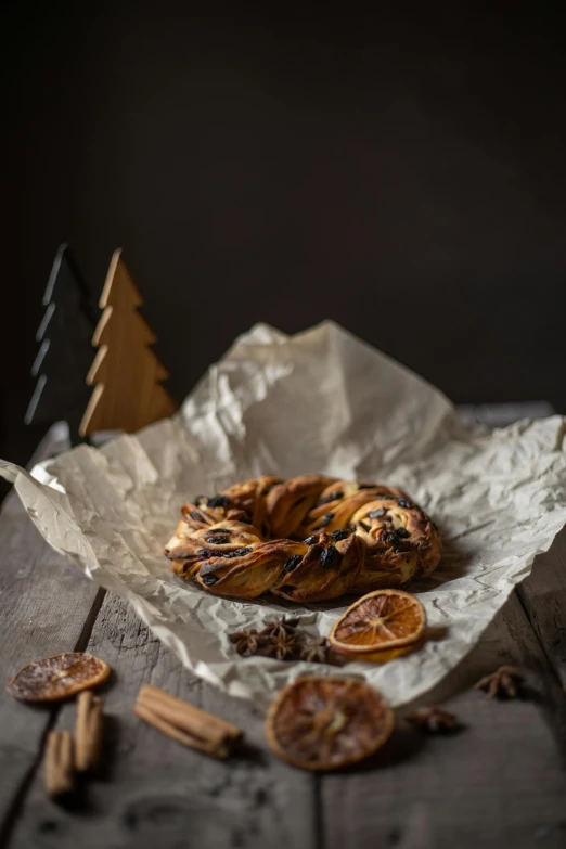 a bagel sitting on top of a piece of paper, pexels contest winner, baroque, christmas, woodland, indoor picture, cinnamon