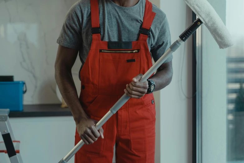 a man in red overalls holding a paint roller, pexels contest winner, holding a thick staff, milkman, detailed cinematic shot, high quality screenshot