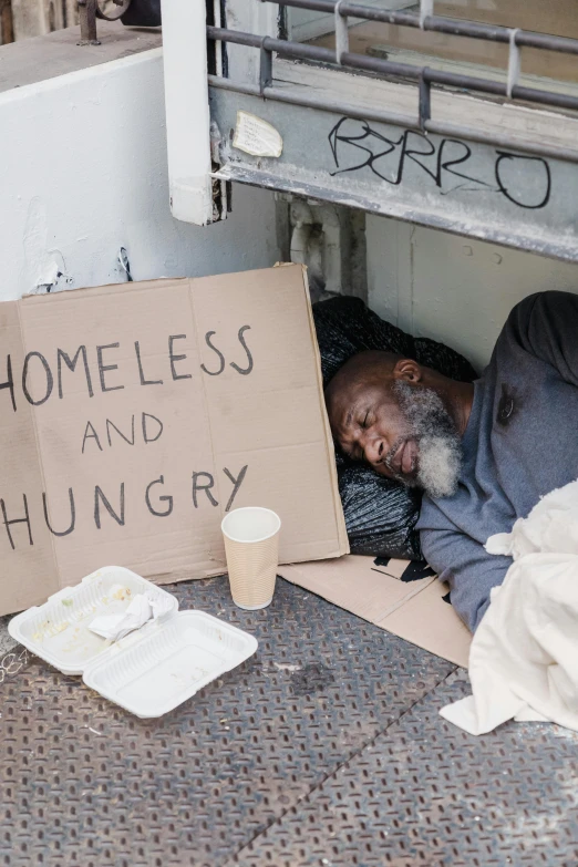 a homeless man with a sign that says homeless and hungry, a photo, trending on unsplash, renaissance, sleeping, mukbang, getty images, dave chappelle