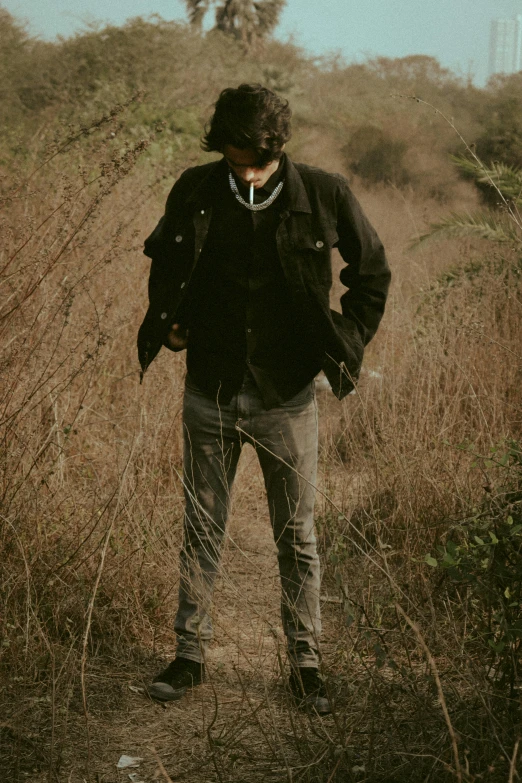a man standing in the middle of a field, an album cover, by Caro Niederer, wearing jacket, disheveled, amongst foliage, sayem reza
