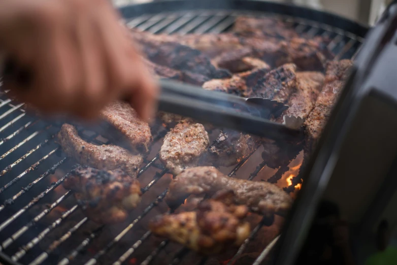 a person is cooking meat on a grill, by Daniel Lieske, pexels contest winner, close up shot from the side, avatar image, thumbnail, angled shot