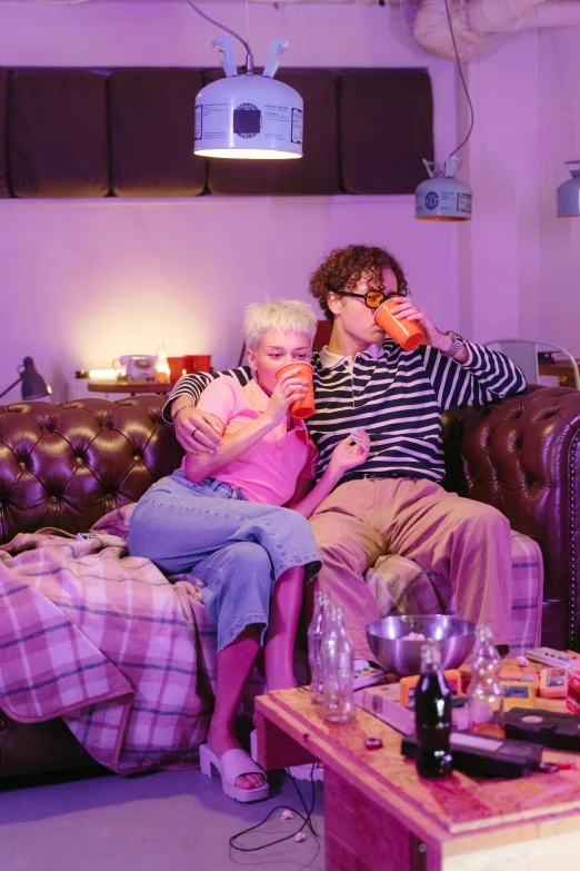 a couple of people that are sitting on a couch, by Lee Gatch, drinking their hearts out, bisexual lighting, ready to eat, immersive