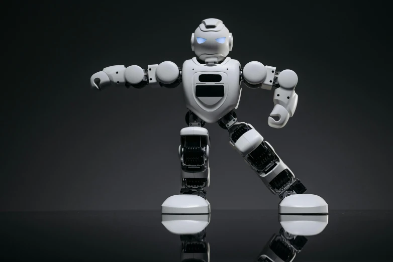 a robot standing in front of a black background, by jeonseok lee, shutterstock, on a gray background, argos, most popular, he is dancing