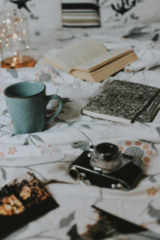 a cup of coffee sitting on top of a bed, a still life, by Carey Morris, pexels contest winner, storybook, blue and grey, 15081959 21121991 01012000 4k, cottagecore hippie