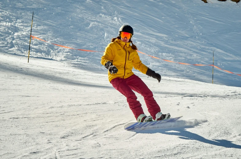 a woman riding a snowboard down a snow covered slope, brightly coloured, tan, customers, yellow