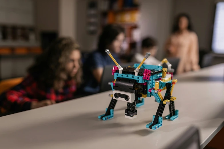 a lego dog sitting on top of a table, robot model kit, vibrant epic, cyan, person in foreground