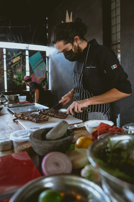 a man preparing food on a table in a kitchen, profile image, mexican warrior, smouldering charred timber, thumbnail