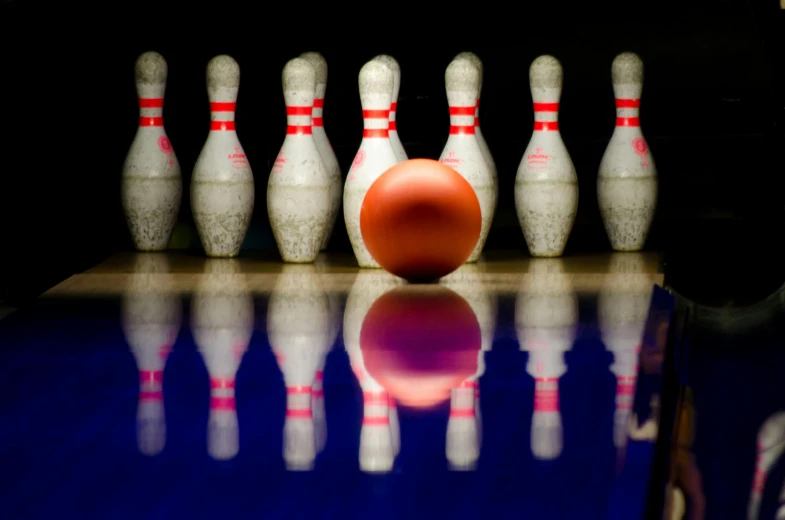 a bowling ball sitting on top of a bowling alley, a picture, by Joe Bowler, pexels contest winner, red and blue reflections, rockets, porcelain, thumbnail