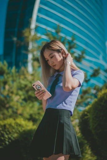a woman in a skirt is looking at her cell phone, trending on pexels, wearing school uniform, avatar image, asian, profile pic
