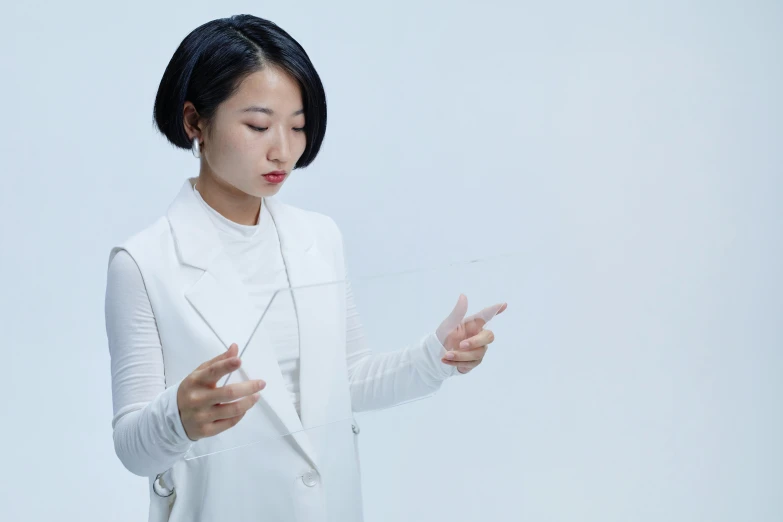 a woman in a white suit holding a cell phone, inspired by Fei Danxu, kinetic art, transparent glass surfaces, product design shot, conductor, white sleeves