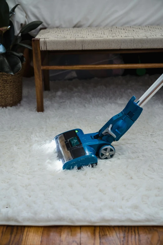 a blue mop sitting on top of a white rug, electric, pulling the move'derp banshee ', volumetric dust, full product shot