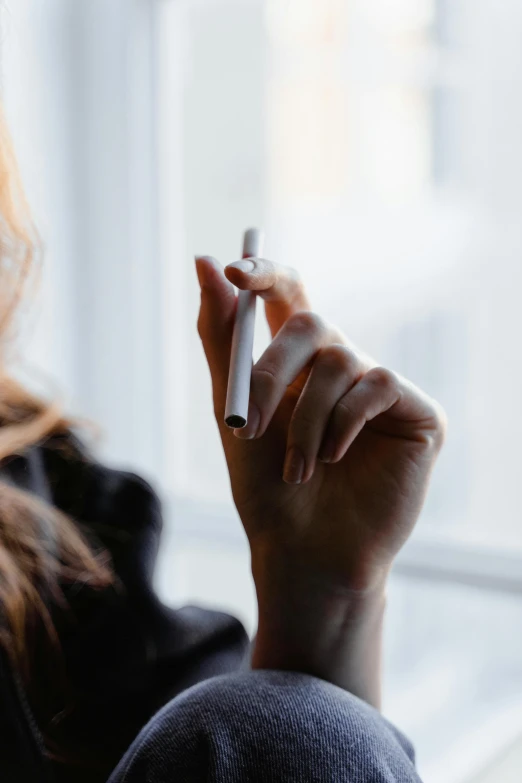 a woman holding a cigarette in one hand and a cigarette in the other, trending on pexels, happening, black chalk, high quality product image”, trailing white vapor, technologies