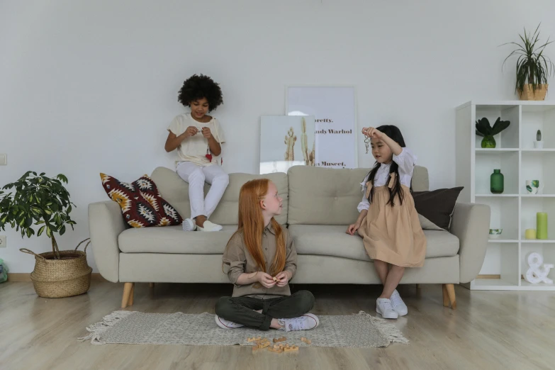 two girls sitting on a couch in a living room, pexels contest winner, brown and white color scheme, three women, light skinned african young girl, plush furnishings