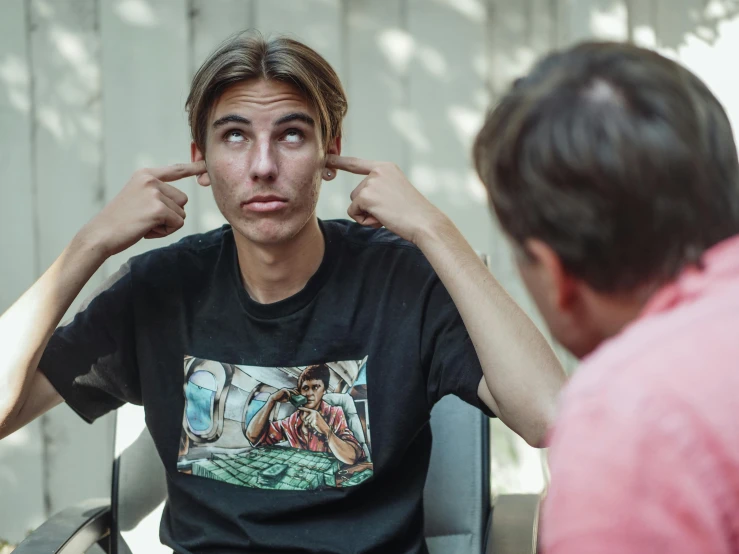 a man sitting in a chair talking to another man, pexels contest winner, hyperrealism, wearing a t-shirt, male teenager, third eye in middle of forehead, thinking pose