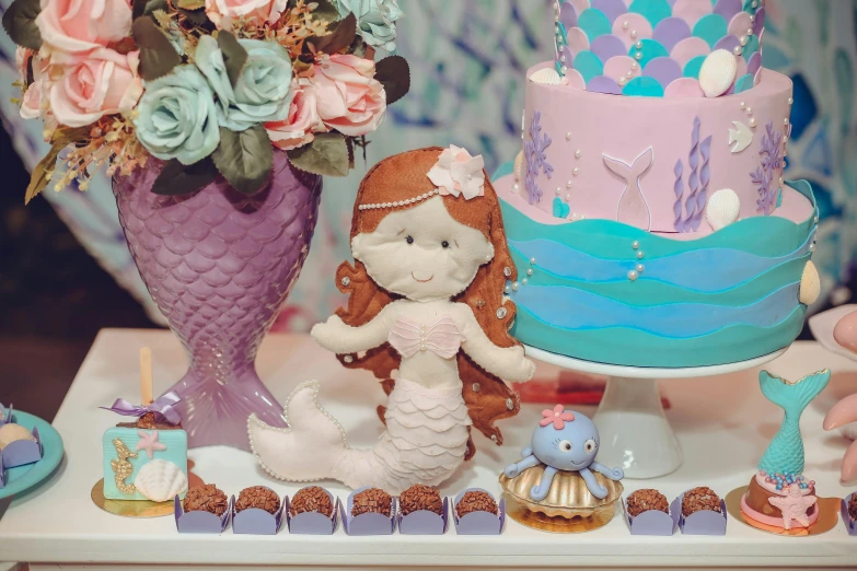 a cake sitting on top of a table next to a vase of flowers, a cartoon, pexels, little mermaid, doll in hand, violet theme, party