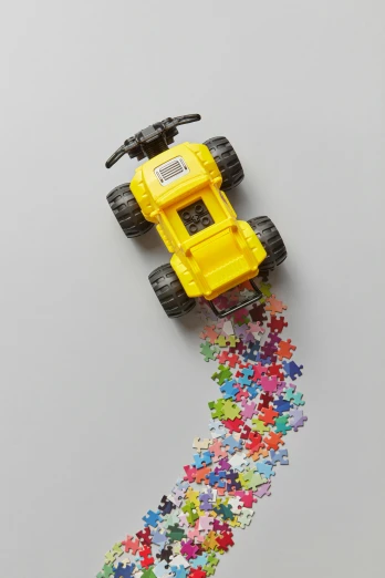 a toy truck sitting on top of a pile of puzzle pieces, a jigsaw puzzle, by Jessie Algie, on a gray background, yellow, top-down shot, off - road