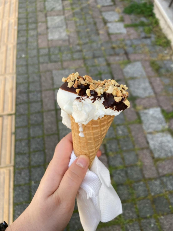 a close up of a person holding an ice cream cone, in karuizawa, instagram post, some chocolate sauce, thumbnail