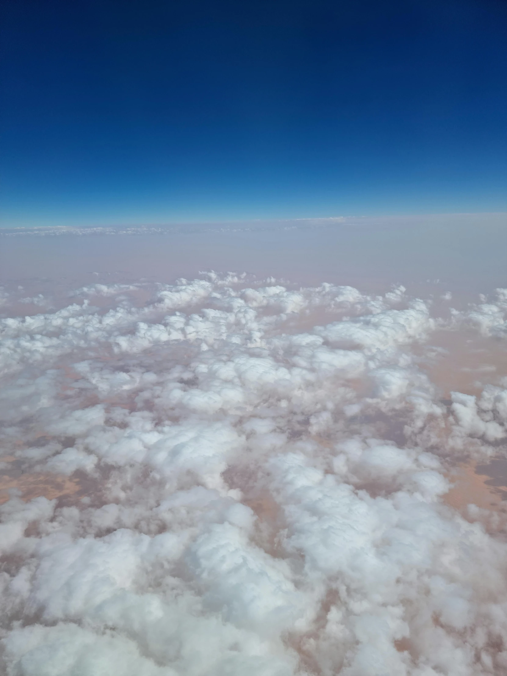 a view of the sky and clouds from an airplane, by Nathalie Rattner, hurufiyya, in a dusty red desert, cotton candy, ☁🌪🌙👩🏾, in the bottom there a lot of fog