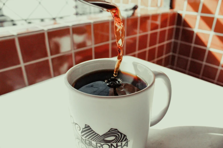 a cup of coffee being poured with a spoon, by Niko Henrichon, trending on unsplash, fan favorite, scorpion tail, exterior shot, california;