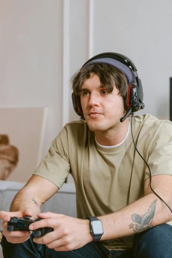 a man sitting on a couch playing a video game, trending on pexels, realism, with head phones, symmetrical face orelsan, discord profile picture, ben watts